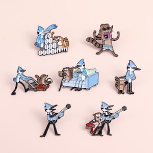 Puede incluir: Una colección de ocho pines de esmalte con los personajes de dibujos animados Mordecai y Rigby en varias poses, incluyendo jugando videojuegos en un sofá azul, cortando el césped, tocando guitarras eléctricas y uno con el texto OOOOOOHHHHH.