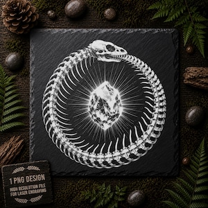 Könnte beinhalten: Eine quadratische schwarze Schieferplatte mit einer weißen, lasergravierten Illustration einer skelettierten Schlange, die einen Kreis bildet, ein Ouroboros, dessen Schädel in den Schwanz beißt. Ein facettierter, leuchtender Kristall ist im Ring zentriert.