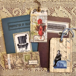 May include: A collection of vintage ephemera, including a blue book with the text "PROPRIETOR OF IDEAS", a brown book with the text "LIST OF ILLUSTRATIONS", a tag with the text "VENTILATED LIVERY HATS", a tag with the text "FARIQUE DE CHAUSST VEMENT POUR A HAYO", a tag with the text "15 July 1877", and a tag with a stamp and the text "CENTENNIAL OF BOOKERY WASHINGTON".