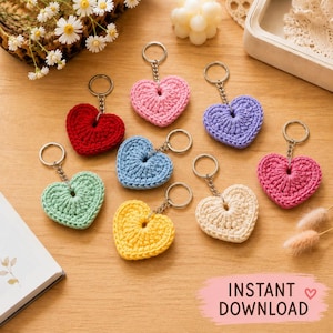 May include: A collection of eight heart-shaped keychains made from crocheted yarn in various colors including red, pink, light blue, mint green, yellow, cream, and purple, each attached to a silver-toned metal split ring with a short chain.