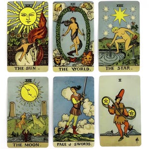May include: Six rectangular tarot cards featuring The Sun, The World, The Star, The Moon, Page of Swords, and Two of Pentacles. Each card displays detailed illustrations with figures, celestial bodies, and symbolic imagery in muted, vintage-style colors.
