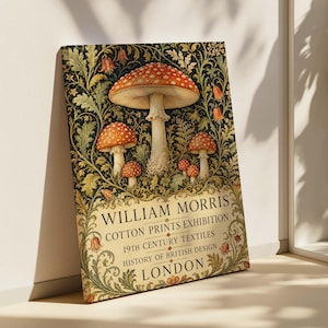 May include: Framed art print featuring a vintage illustration of mushrooms with red caps and white spots. The artwork is set against a dark floral background and includes text that reads "William Morris Cotton Prints Exhibition, London."