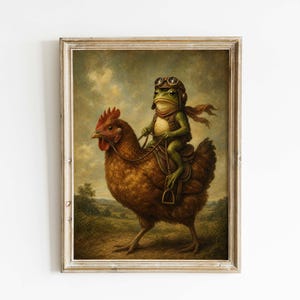 May include: A framed vintage-style print depicts a green frog wearing a pilot's helmet and scarf, riding a brown chicken. The artwork has a whimsical, surreal quality, with a detailed, painterly style and a neutral background.