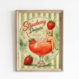 May include: Vintage-style framed print featuring a strawberry daiquiri illustration. The artwork showcases a woman with a strawberry head, sitting on a large cocktail glass filled with ice and a red drink. The text "Strawberry Daiquiri" is displayed in a retro font.