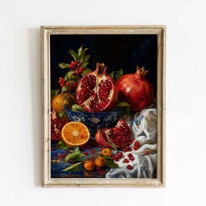 May include: Framed still life painting featuring pomegranates, oranges, and berries. A halved pomegranate reveals its seeds, while a whole one sits beside it. Oranges and berries are scattered around a blue and white bowl. The artwork is set against a dark background.