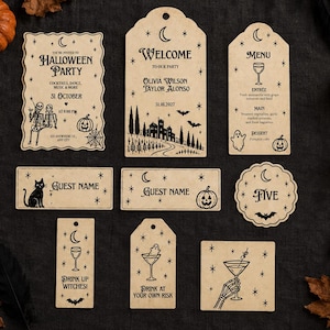 May include: A set of beige paper Halloween party stationery including an invitation, menu, place cards, and tags. Each piece features black ink illustrations of skeletons, pumpkins, ghosts, bats, cats, and stars with crescent moon motifs.