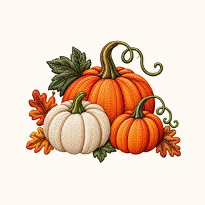 May include: An embroidered illustration of three pumpkins in orange and cream colours. The design features a large orange pumpkin, a smaller cream pumpkin, and a smaller orange pumpkin, all accented with green stems, curly vines, and autumn leaves.
