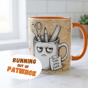 May include: A ceramic mug with an orange handle and interior, featuring a graphic of a grumpy mug character holding scissors, a pencil, and a ruler. A small note taped to the mug reads "Can you just..." and the text "RUNNING OUT OF PATIENCE" is visible.