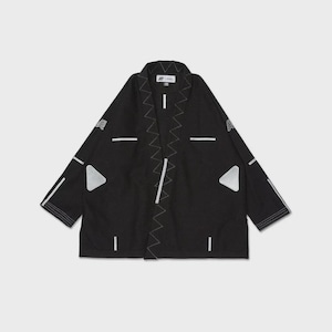 Peut inclure: Une veste noire de style kimono avec des coutures en zigzag blanches le long de l'ouverture avant, des accents de lignes horizontales blanches et deux écussons triangulaires argentés sur la poitrine. Une étiquette blanche avec du texte noir.