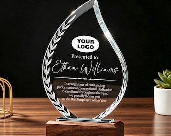 May include: A flame-shaped clear glass award trophy mounted on a rectangular dark wood base. The glass features an etched laurel leaf border, a placeholder oval for a logo, and text reading: Presented to Ethan Williams, In recognition of outstanding performance and exceptional dedication to excellence throughout the year, we proudly honor you as the Best Employee of the Year.