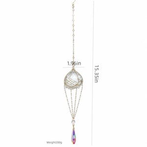 Puede incluir: Un adorno de cristal colgante con una esfera transparente facetada en una jaula de alambre dorado, suspendido por una cadena fina. Mide 4,98 cm de ancho y 39 cm de largo, con un colgante iridiscente en forma de l&aacute;grima y un peso de 200g.