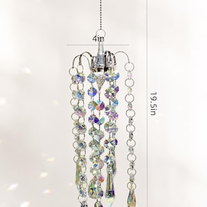 Puede incluir: Un adorno colgante de cristal tipo candelabro con cuentas facetadas iridiscentes y prismas en forma de l&aacute;grima suspendidos de una estructura plateada. Mide 10,16 cm de ancho, 49,53 cm de alto y tiene un peso total de 200 gramos.