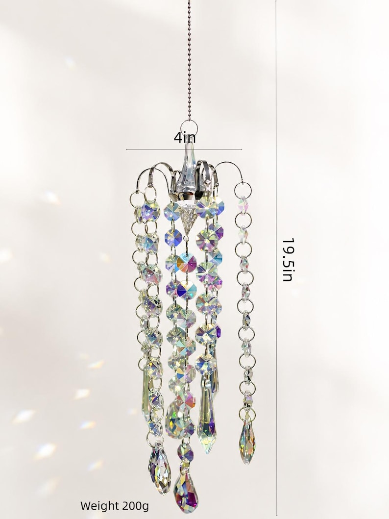 Puede incluir: Un adorno colgante de cristal tipo candelabro con cuentas facetadas iridiscentes y prismas en forma de l&aacute;grima suspendidos de una estructura plateada. Mide 10,16 cm de ancho, 49,53 cm de alto y tiene un peso total de 200 gramos.