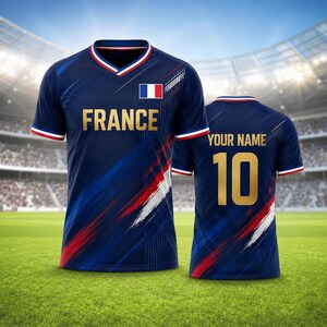 Puede incluir: Una camiseta de f&uacute;tbol azul marino con la palabra "FRANCE" en letras doradas en la parte delantera. La camiseta presenta la bandera francesa y detalles en rojo, blanco y azul. La parte trasera de la camiseta tiene el n&uacute;mero 10 y el texto "YOUR NAME" en dorado.