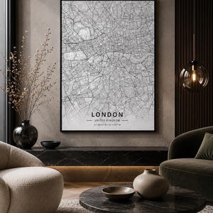 May include: A framed vertical wall art print featuring a detailed black and white street map of London, United Kingdom. The print includes the text LONDON, UNITED KINGDOM, and the coordinates 51.4931°N / 0.1157°W centred at the bottom.