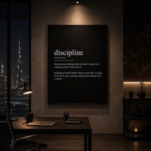 Könnte beinhalten: Ein schwarzes Wandbild mit dem Wort discipline in weißer Schrift, gefolgt von der phonetischen Aussprache und einer Definition: die Praxis, das zu tun, was man nicht tun möchte, wenn man es nicht tun will, und sich selbst weiter voranzubringen.