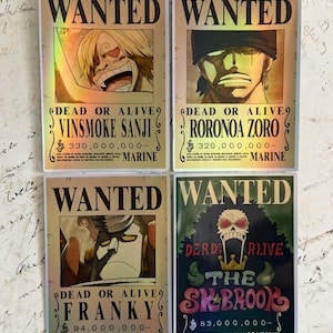 May include: Four rectangular stickers featuring One Piece character wanted posters. Three are gold with holographic accents showing Vinsmoke Sanji, Roronoa Zoro, and Franky. The fourth is green with a skull graphic for Brook. All include text.