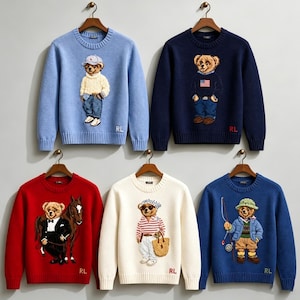 Puede incluir: Cinco suéteres de punto de manga larga en azul claro, azul marino, rojo, crema y azul real. Cada suéter presenta un oso bordado en el centro vestido con diferentes atuendos, incluido un esmoquin con un caballo, y las letras RL.