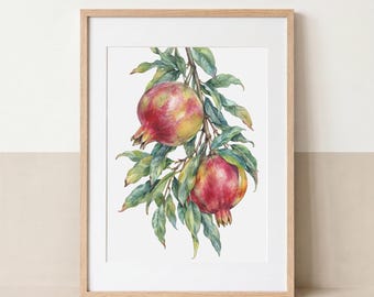 May include: A framed wall art print featuring a watercolor illustration of two pomegranates hanging from a branch with green leaves. The artwork is encased in a light-colored wooden frame with a white mat border, displaying botanical fruit art.