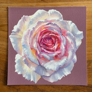 May include: A square art print featuring a detailed painting of a single rose. The flower has layered petals transitioning from deep magenta and pink at the centre to soft white and pale lavender at the edges, set against a solid mauve background.