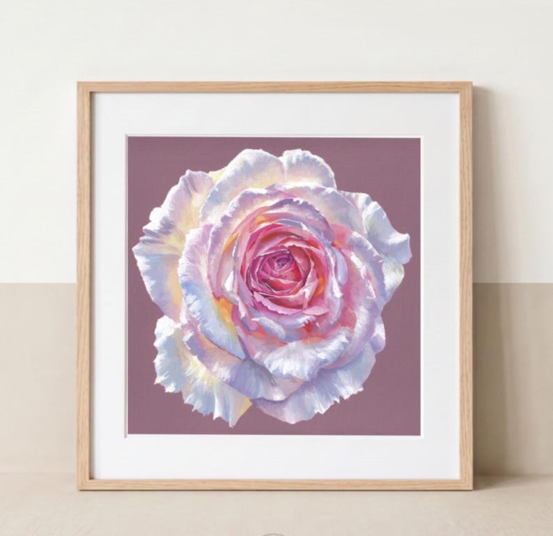 Pink rose botanical art print displayed in a natural wood frame on a neutral wall