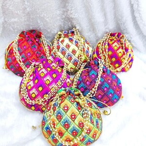Peut inclure: Un ensemble de six pochettes à cordon présentant des motifs en losange multicolores et vibrants avec des détails brodés et de petits miroirs circulaires. Chaque pochette est dotée d'une anse en perles blanches et d'une fermeture à cordon.