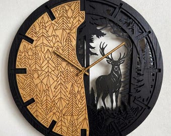 Puede incluir: Un reloj de pared circular con un diseño dividido. El lado izquierdo muestra un acabado en madera natural con patrones geométricos de pinos cortados con láser. El lado derecho es negro con la silueta recortada de un ciervo.