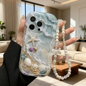 Könnte beinhalten: Transparente Handyhülle mit Strandmotiv, mit Seestern, Muscheln und Perlen. Die Hülle hat ein wellenartiges Muster in Blau- und Weißtönen. Ein klarer Perlenriemen mit Schmetterlings- und Schleifenakzenten ist angebracht.