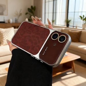 May include: A burgundy and silver phone case with a textured leather-like panel. The case has a dual-camera cutout and the text "CASE AITO" is printed on the side.