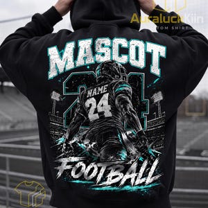 Puede incluir: Una sudadera con capucha negra que presenta un gran gráfico en la parte posterior. El diseño incluye el texto MASCOT y FOOTBALL en blanco y turquesa, con una ilustración central de un jugador de fútbol americano con el número 24 y NAME.