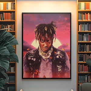 Peut inclure: Une impression d'art mural rectangulaire encadrée représentant le portrait d'une personne aux dreadlocks portant un gilet noir orné d'épingles et du texte MCMXCVIII, MXIX et Legends Never Die, sur un fond de coucher de soleil rouge vif avec des papillons.