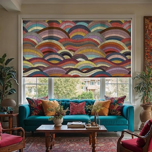 May include: A window roller shade with a colorful, abstract wave pattern in shades of red, orange, yellow, blue, and brown. The shade is installed in a window above a teal sofa with decorative pillows.