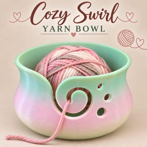 May include: A gradient-colored yarn bowl in shades of pastel green and pink, featuring a spiral cutout for yarn and three circular holes. The text "Cozy Swirl YARN BOWL" is displayed above the bowl, accompanied by line-art hearts and a yarn ball.