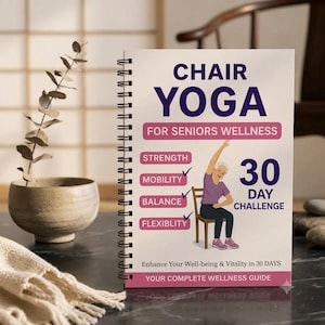 May include: A spiral-bound book titled CHAIR YOGA FOR SENIORS WELLNESS 30 DAY CHALLENGE. The cover features a purple and white design with an illustration of a person sitting on a chair, along with the text STRENGTH, MOBILITY, BALANCE, and FLEXIBLITY.