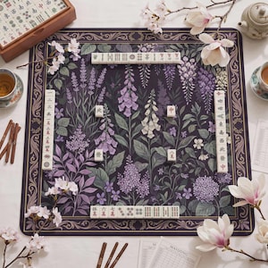 May include: A square mahjong mat featuring a dark purple background with a botanical print of lavender, foxgloves, and wisteria. The mat has a decorative border and is arranged with white mahjong tiles, wooden scoring sticks, and score sheets.