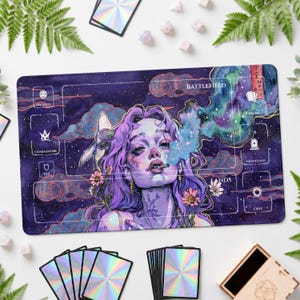 May include: A rectangular playmat featuring a purple and blue cosmic background with a central illustration of a person with purple hair, surrounded by flowers and a whale. The mat includes white game zone labels like Battlefield, Library, and Graveyard.