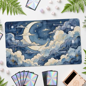 Pode incluir: Um tapete de jogo retangular com uma ilustração em aguarela de uma lua crescente e nuvens em tons de azul escuro, creme e dourado. O tapete inclui zonas impressas com as etiquetas Battlefield, Life Total, Commander, Tax, Graveyard, Lands e Exile.