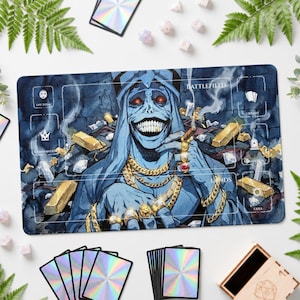 May include: A rectangular playmat featuring a blue-skinned character with red eyes and a wide grin, wearing gold chains and rings, surrounded by gold bars and diamonds. The mat includes labeled zones for Battlefield, Library, Lands, and Life Total.