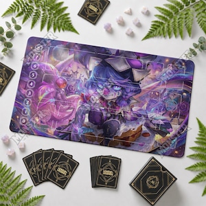 May include: A rectangular gaming playmat featuring a vibrant purple and blue illustration of a character with blue hair, surrounded by game card zones and numbered circles from zero to six. Includes a deck of black cards and a matching card box.