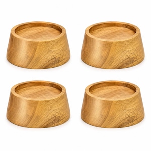 May include: A set of four circular wooden coasters, each featuring a natural light brown wood grain pattern. The coasters have a tapered, sloped side profile and a recessed flat top surface designed to hold items securely in place.