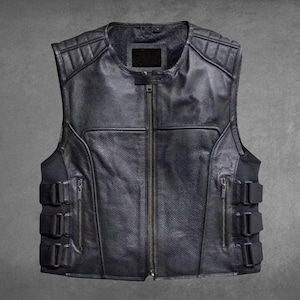 May include: A black leather vest featuring a central zipper closure, a round neckline, and quilted shoulder panels. The sides include vertical zippered pockets and three adjustable buckle straps on each side for a secure fit.