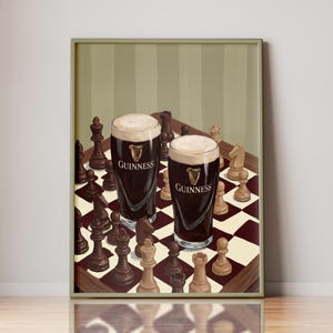 Peut inclure: Une impression d'art murale encadr&eacute;e repr&eacute;sentant deux verres de bi&egrave;re brune avec une mousse blanche cr&eacute;meuse, chacun portant le logo Guinness, plac&eacute;s sur un &eacute;chiquier entour&eacute; de diverses pi&egrave;ces d'&eacute;checs en bois clair et fonc&eacute;.