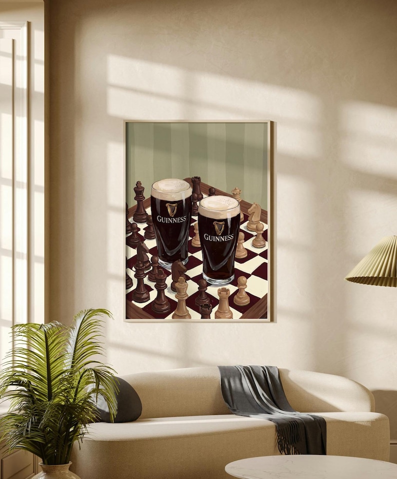 Peut inclure: Une impression d'art encadr&eacute;e repr&eacute;sentant deux pintes de bi&egrave;re brune Guinness avec une mousse blanche cr&eacute;meuse, plac&eacute;es sur un &eacute;chiquier parmi diverses pi&egrave;ces d'&eacute;checs en bois clair et fonc&eacute;, incluant cavaliers, tours et pions.