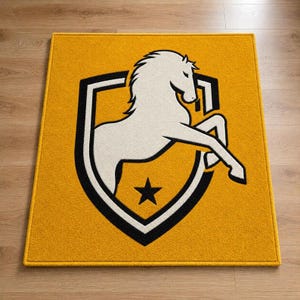 Könnte beinhalten: Ein quadratischer Teppich mit senfgelbem Hintergrund und einem zentralen schwarz-weißen Wappenemblem. Das Wappen zeigt die Silhouette eines steigenden weißen Pferdes und einen kleinen schwarzen fünfzackigen Stern unter dem Pferd.