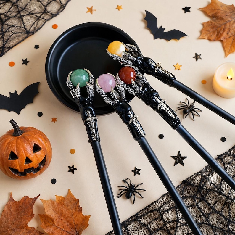 May include: Four wands with black shafts and silver-toned claw-shaped tops, each holding a different colored sphere: green, light pink, reddish-brown, and yellow. The claw designs feature intricate sword-like detailing on the handle base.
