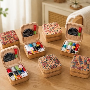 May include: A collection of square cork sewing kits with patterned lids. Each kit contains colourful thread spools, a small pair of scissors, a thimble, and a circular case labelled "10 Assorted Needles" tucked into the interior lid pocket.