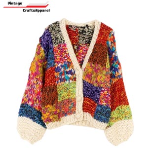 May include: A colorful patchwork cardigan with a V-neck and button closure. The sweater features a variety of vibrant colors and textures, including red, purple, yellow, and blue. The text "Vintage CraftsApparel" is at the top left.