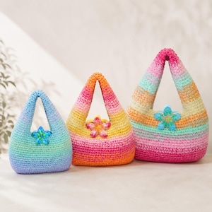 May include: Three crochet handbags in varying sizes, each featuring a gradient color pattern and a single integrated handle. The smallest bag is blue and green, the middle is orange and pink, and the largest is a multi-colored pastel blend.