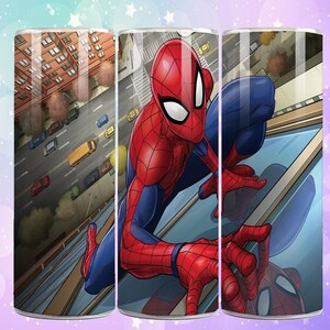 Puede incluir: Un vaso cil&iacute;ndrico con una vibrante ilustraci&oacute;n de Spider-Man con su ic&oacute;nico traje rojo y azul. El dise&ntilde;o muestra a Spider-Man aferrado a un edificio, con un paisaje urbano de fondo. El vaso es cil&iacute;ndrico y parece ser de material brillante.