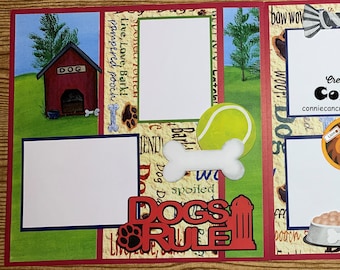 May include: A scrapbook layout with a dog theme. It features a red dog house, a tennis ball, a bone, and the words "DOGS RULE." The layout includes blank spaces for photos and decorative elements like paw prints and a fire hydrant.